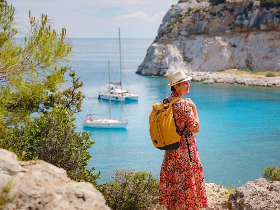 Resenär blickar ut över en turkos vik på Rhodos