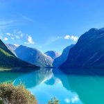 Norsk fjord med turkost vatten och höga berg