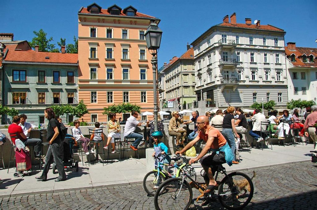 Ljubljana i Slovenien med uteserveringar och cyklister