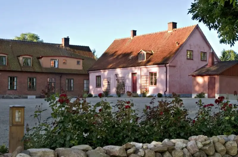 Brösarps Gästgifveri och Spa med rosa hotellbyggnad och rosor på Österlen