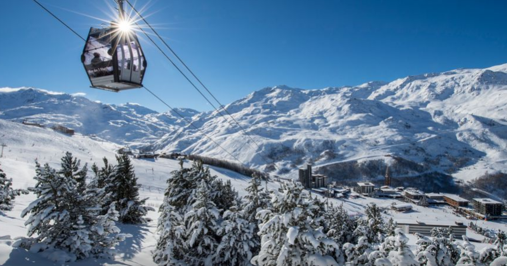 Gondollift över snötäckta granar och skidbackar i Les Menuires i franska Alperna.