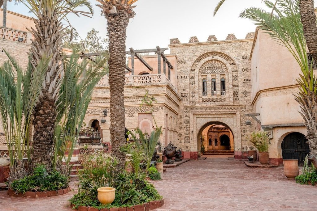 Traditionell marockansk byggnad med palmer och innergård i Agadir